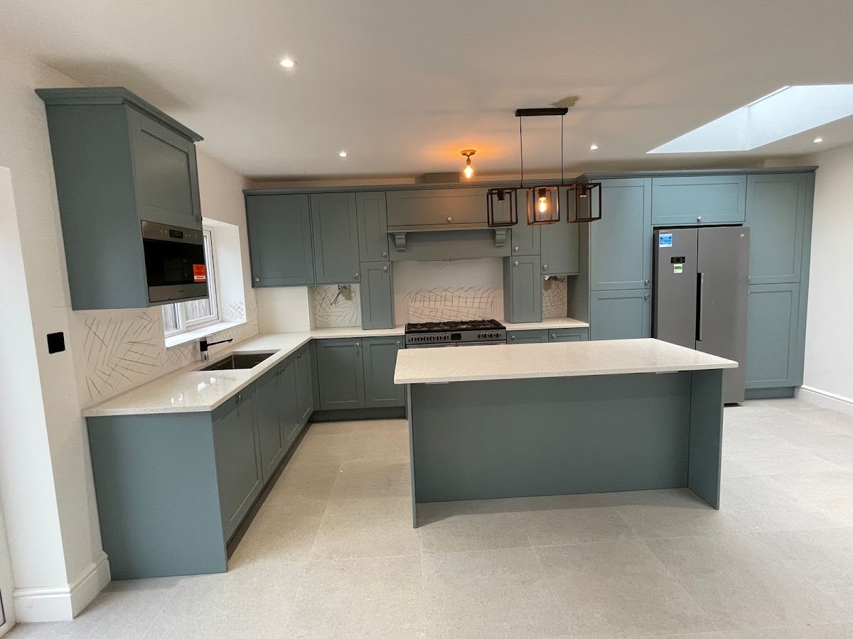 Sage-grey fitted kitchen with island by Taj Kitchen & Bedroom Ltd