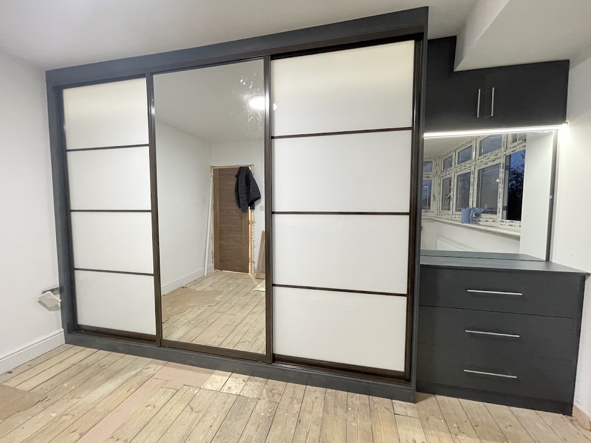 Dark framed sliding wardrobe and dressing drawers
