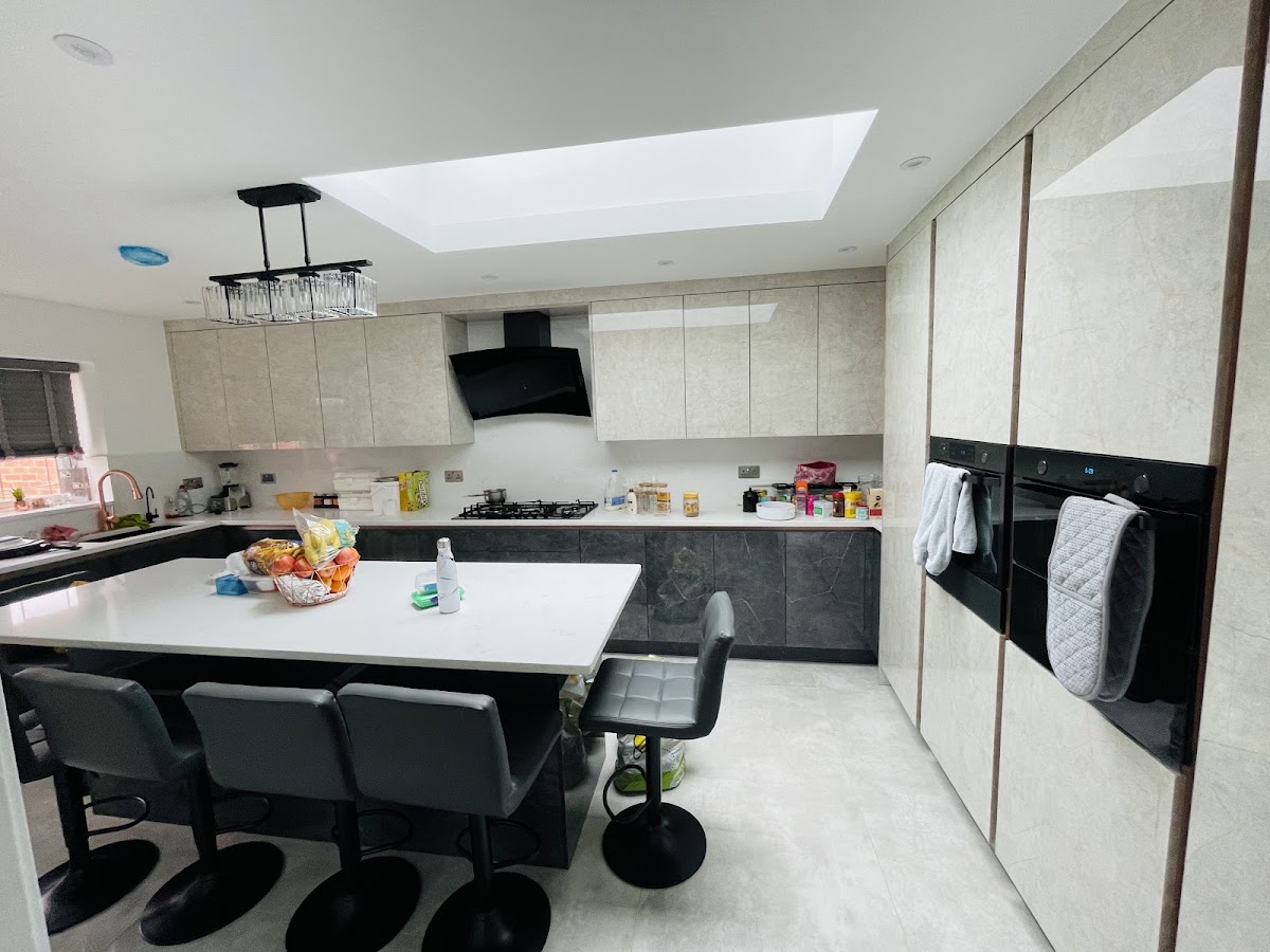 Two-tone fitted kitchen with island and appliance wall
